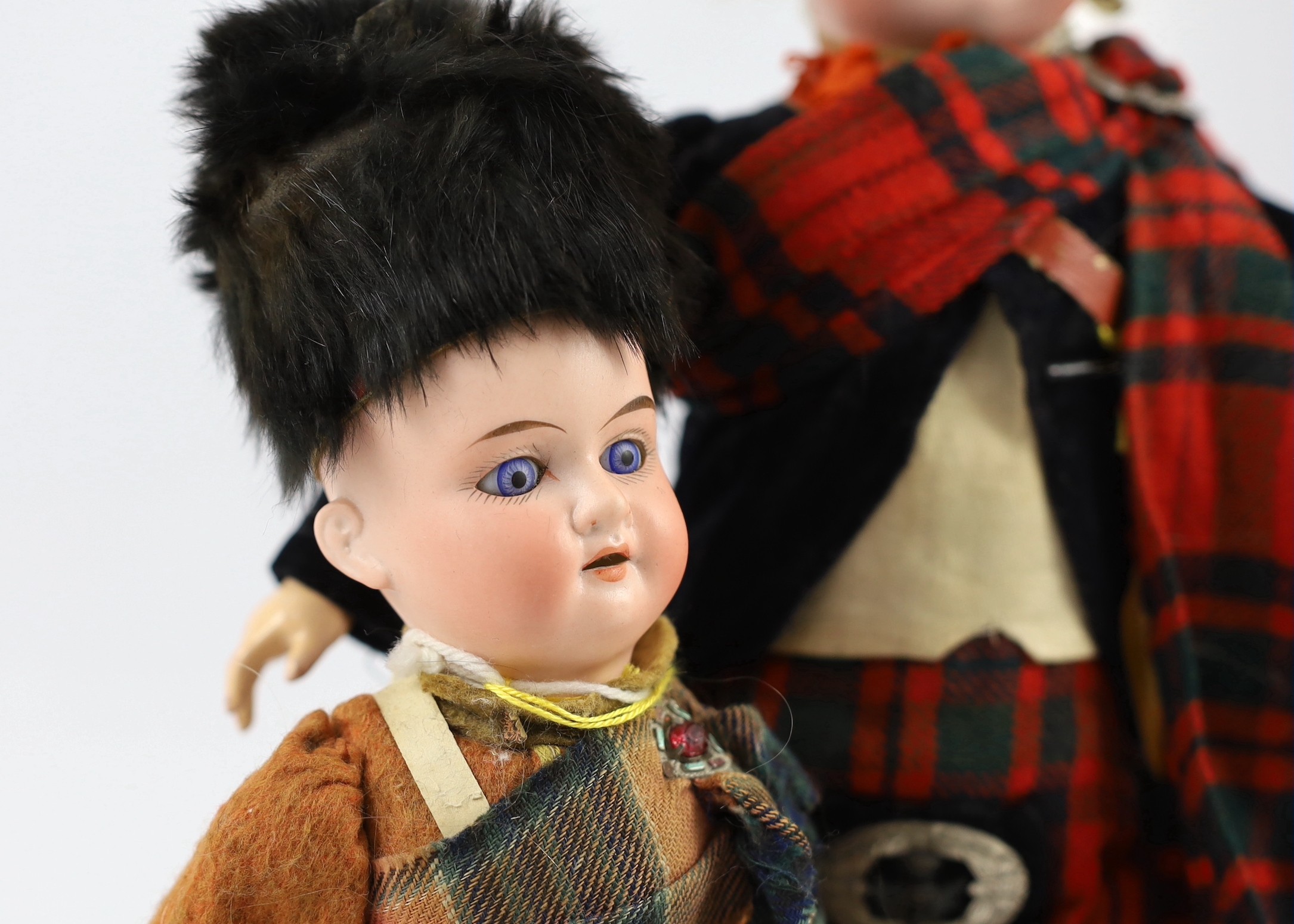 An Armand Marseille bisque Scottish soldier doll, German, circa 1900, 15in. (2)